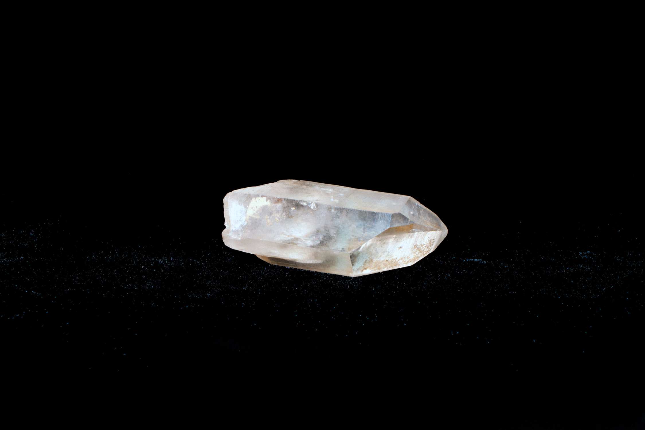 A small piece of clear quartz on a black background.