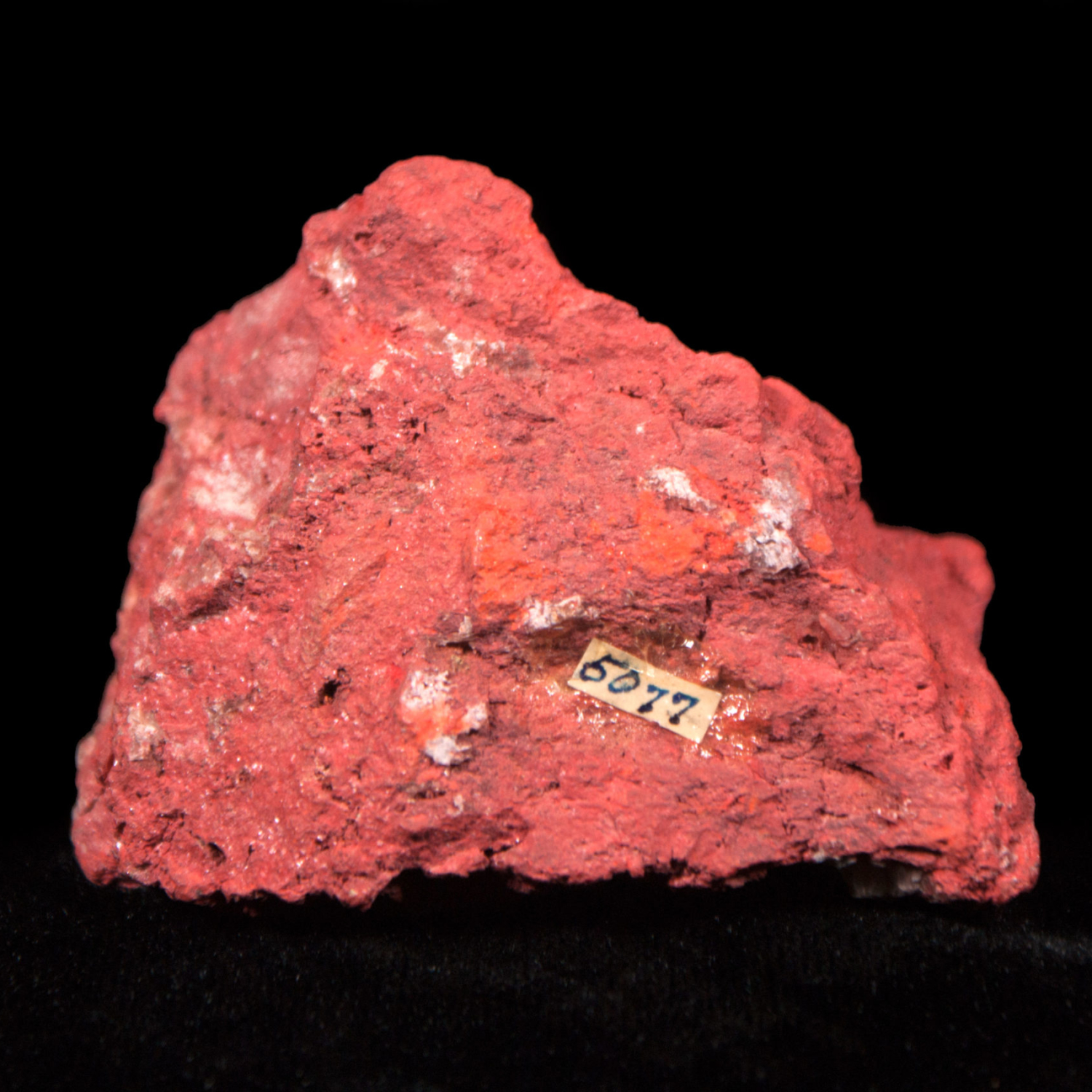 A sample of red cinnabar on a black background.