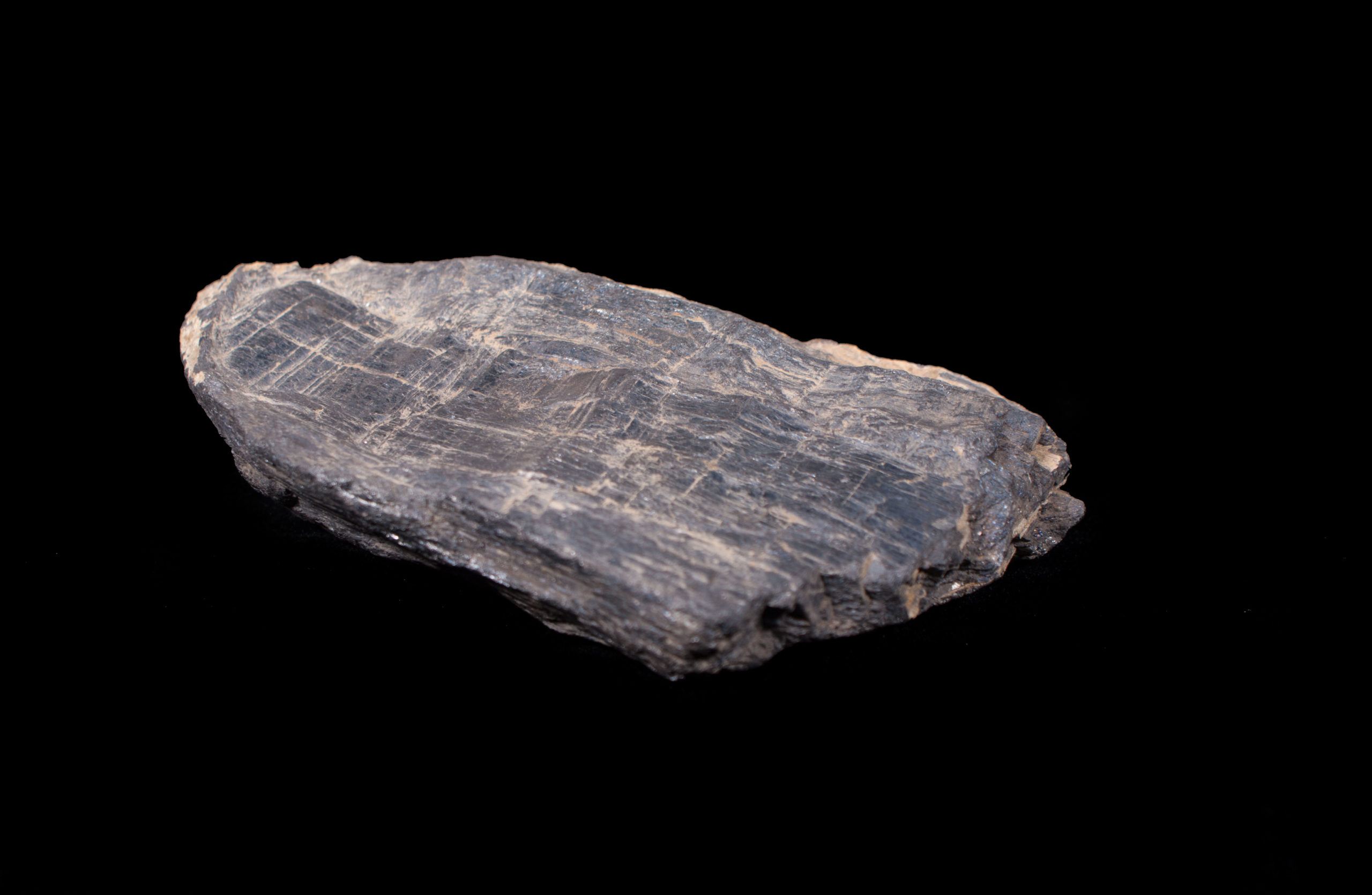 A black and grey rock on a black background.