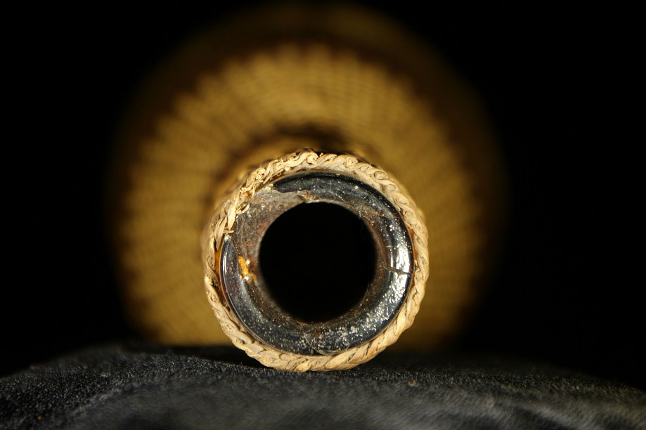 Close up of the top of a glass bottle wrapped in basketry, made by the Klamath River Tribes