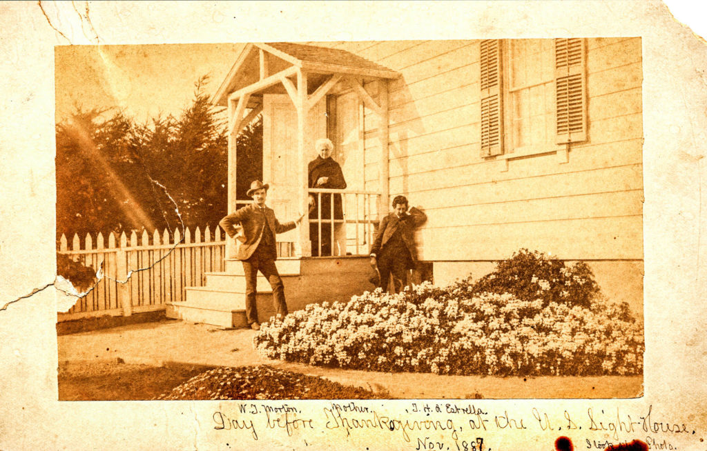 Historic image of 3 people on the steps of the Santa Cruz Lighthouse.