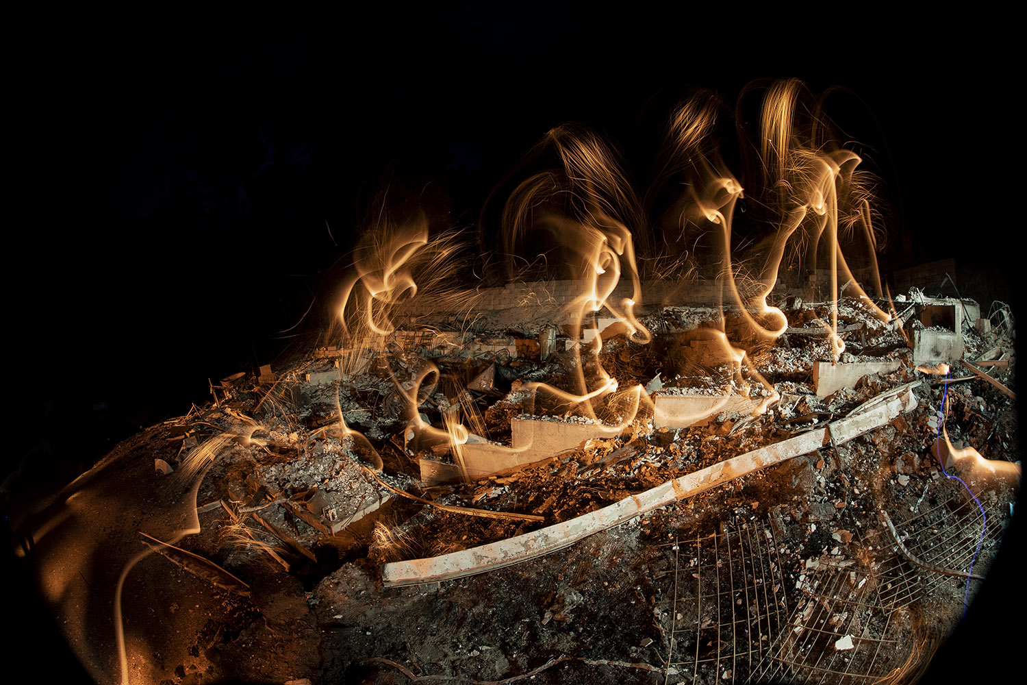 Fire forms twirls above ashy stairs.